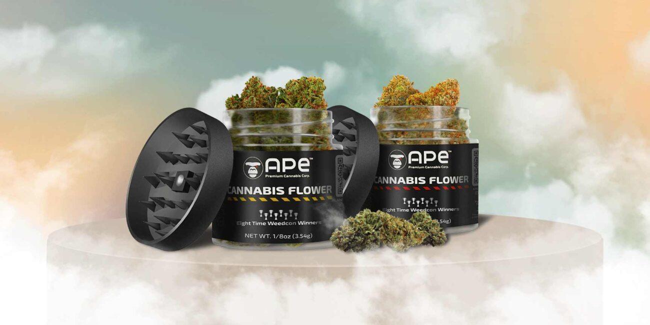 Two packs of APE Premium Weed Strains with grinder on a pedestal in the smoke