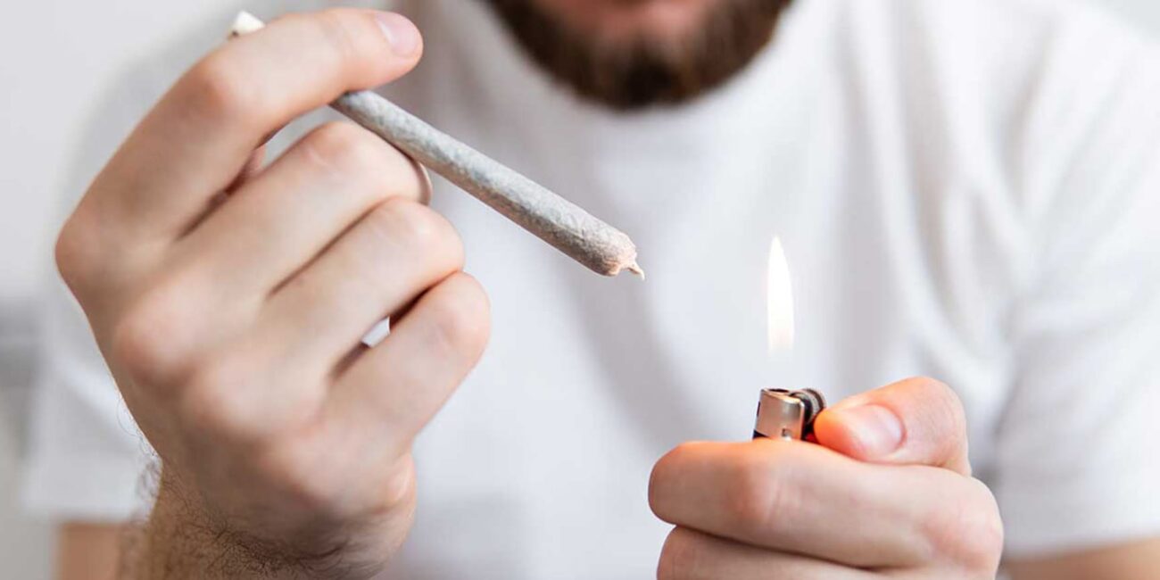 A man sets fire to a joint