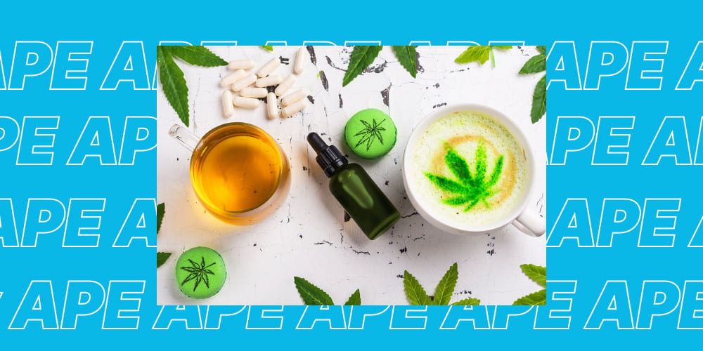 Best 5 THC Drinks A flat lay showing a glass cup of amber tea, a dark green dropper bottle, white pills, green cannabis-leaf themed macarons, and a white mug with a green cannabis leaf design in latte art. All are on a textured white surface with green leaves and a blue background with "APE" text.