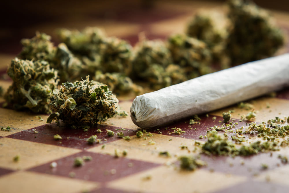 Ape Premium Pre-rolls: Smooth, Strong, and Stylish Hand reaching for an Ape Premium Pre-roll in a cozy setting