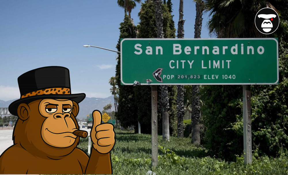 A cartoon ape in a top hat giving a thumbs up next to a green San Bernardino City Limit sign.