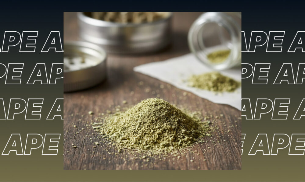 A pile of finely ground cannabis kief on a wooden table with a silver grinder.