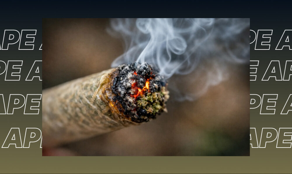 Extreme close-up of a burning cannabis joint with glowing embers and smoke.